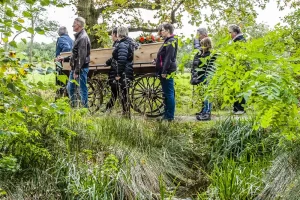 Een uitvaartprocessie in het groen. Uitvaart in scene gezet